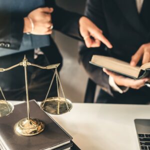 Two legal professionals discussing while pointing at a book