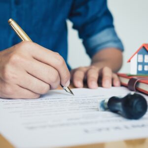Person signing legal documents with a pen