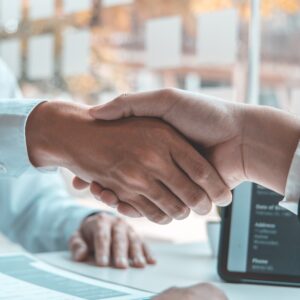 Close-up of a handshake between two people across a desk