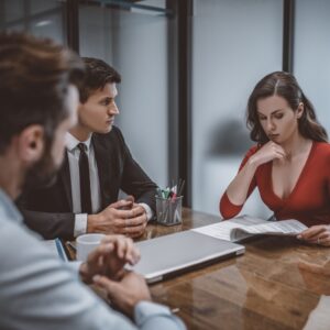 Three professionals in a serious meeting reviewing documents