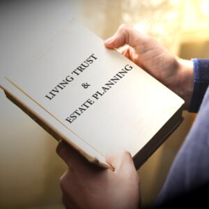 Person holding a book titled "Living Trust & Estate Planning"