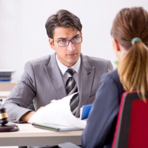 Lawyer speaking to client across desk with gavel