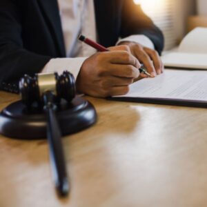 Lawyer writing document beside judge's gavel