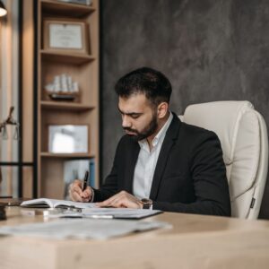 Lawyer signing legal documents at office desk