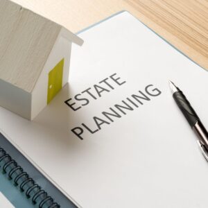 Estate planning document with pen and house model