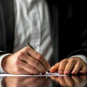 Man signing legal document with fountain pen