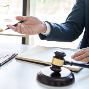 Lawyer gesturing while discussing notes with gavel nearby