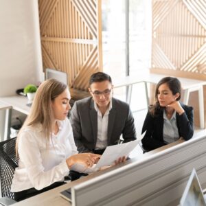 Professional team reviewing paper together at modern desk