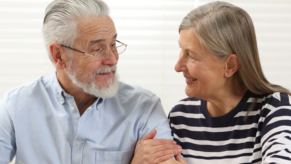 Elderly couple smiling while signing legal documents