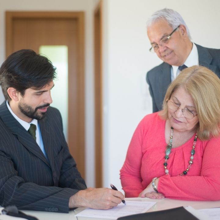 Lawyer explaining documents to an older couple for estate planning