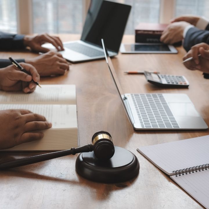 Legal meeting with notebooks, laptops, and a gavel